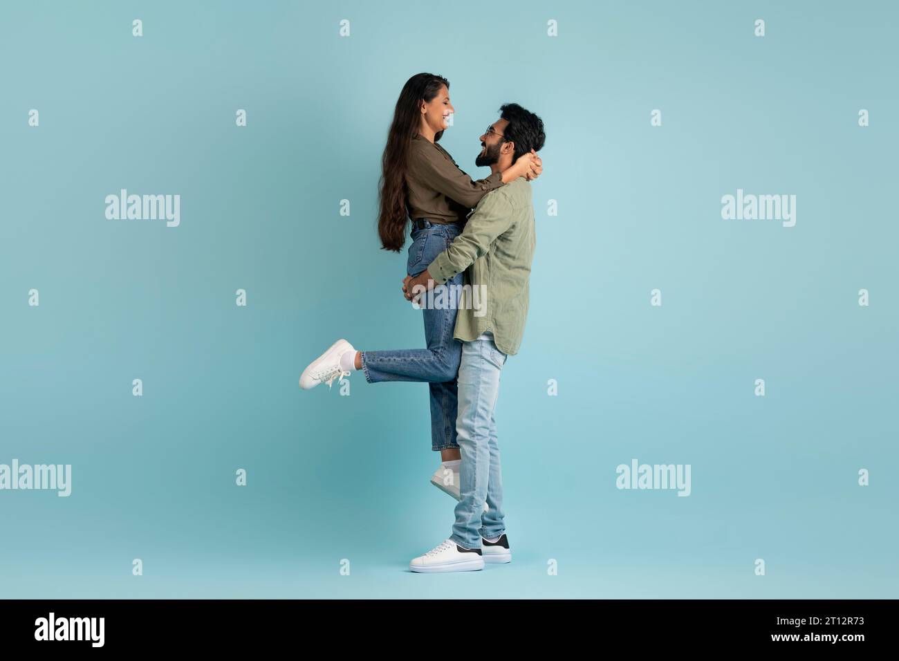 Loving handsome middle eastern guy lifting up his girlfriend Stock Photo