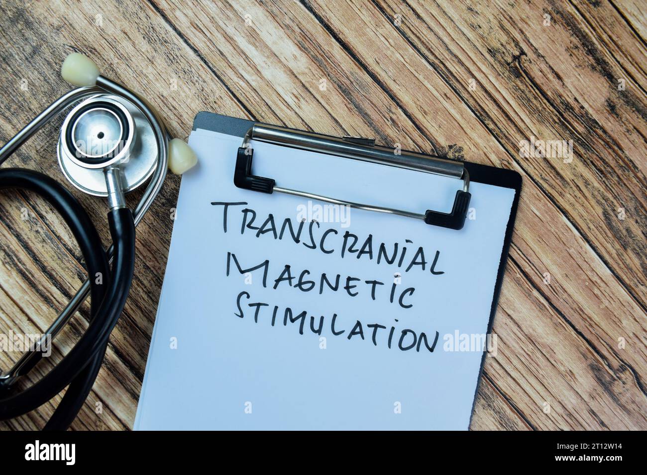Concept of Transcranial Magnetic Stimulation write on paperwork isolated on Wooden Table. Stock Photo