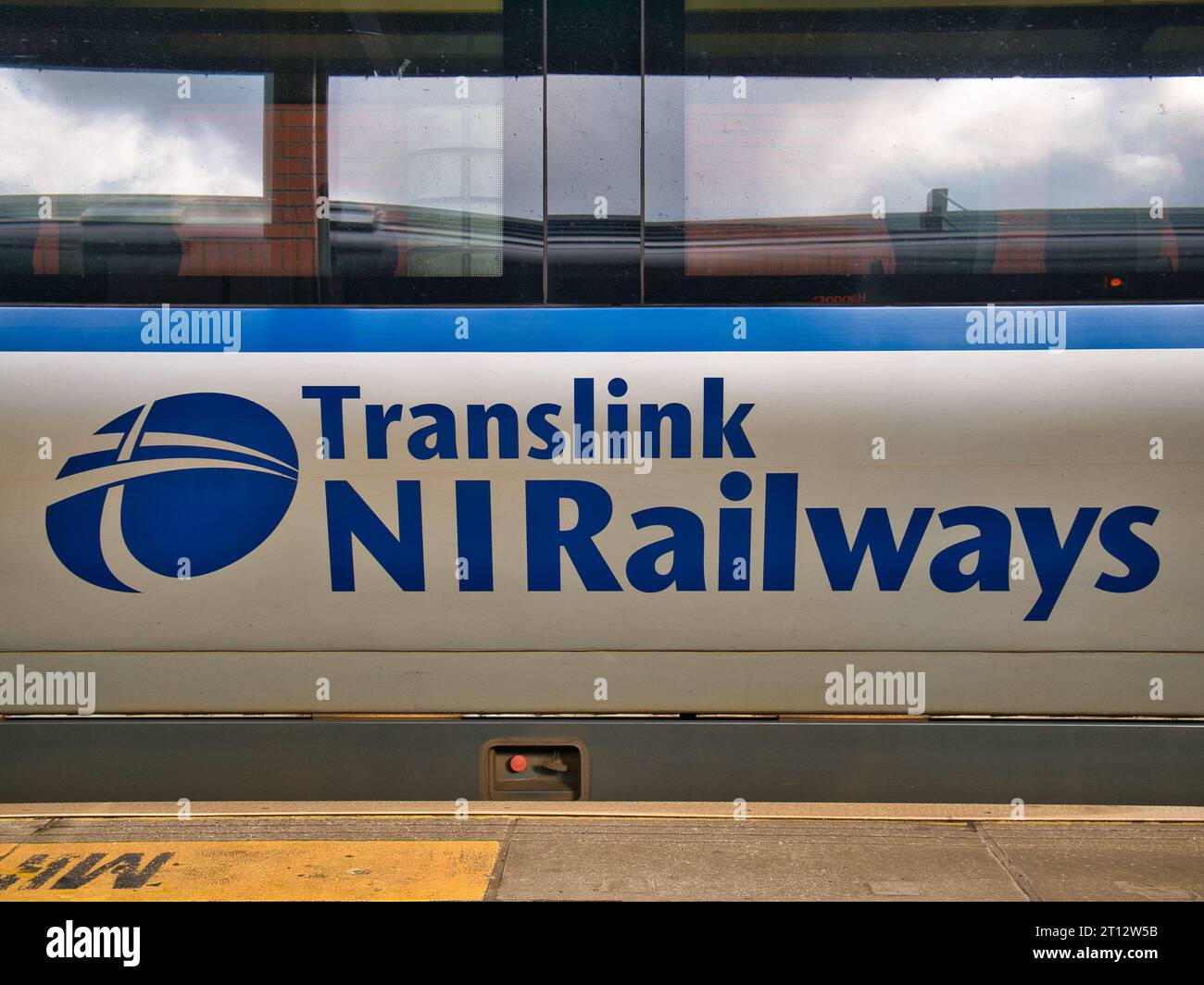Blue corporate branding on the side of a grey - silver Translink railway carriage in Northern Ireland, UK. Stock Photo
