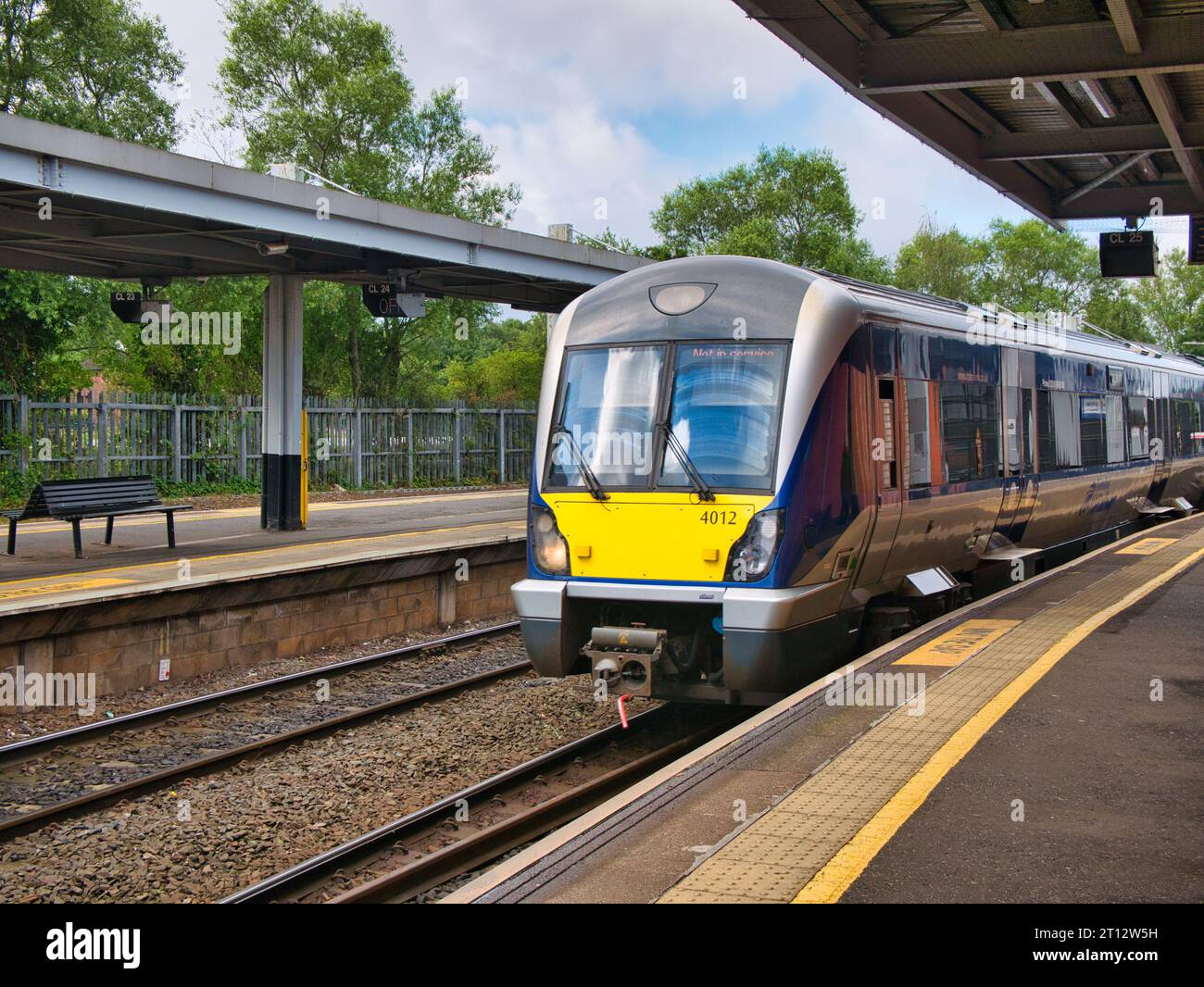 A local commuter train arrives at a deserted platform at Lanyon Place Station in Belfast, Northern Ireland, UK. Taken on a sunny day in summer. Stock Photo