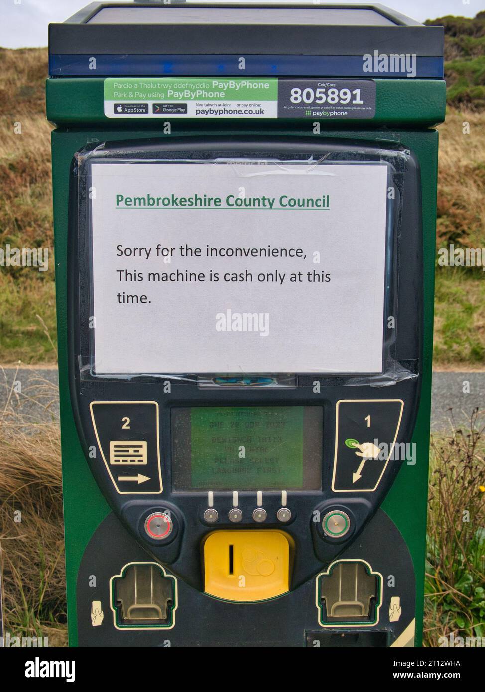 A temporary paper printed sign on a parking meter at Newgale Beach on the Pembrokeshire Coast in Wales Stock Photo