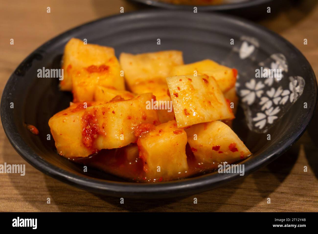Spicy Korean fermented or aged radish known as Kimchi which is a traditional mainstay in Korean cuisine. Stock Photo