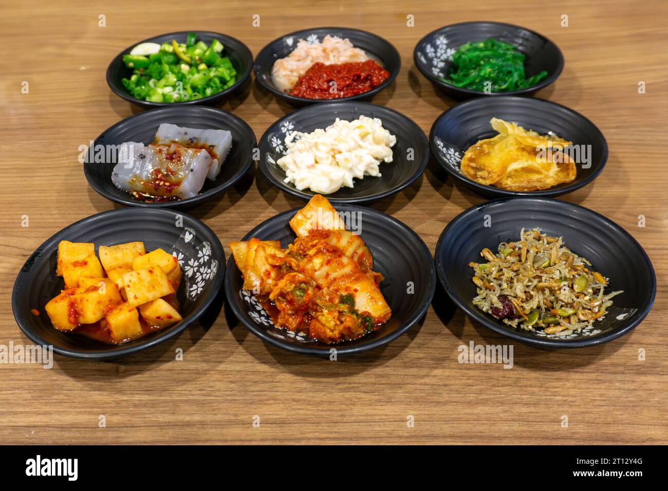 Various Korean home-style side dishes including kimchi, pickled radish, anchovies, konjac, spicy bean paste, and seaweed. Typically served with every Stock Photo