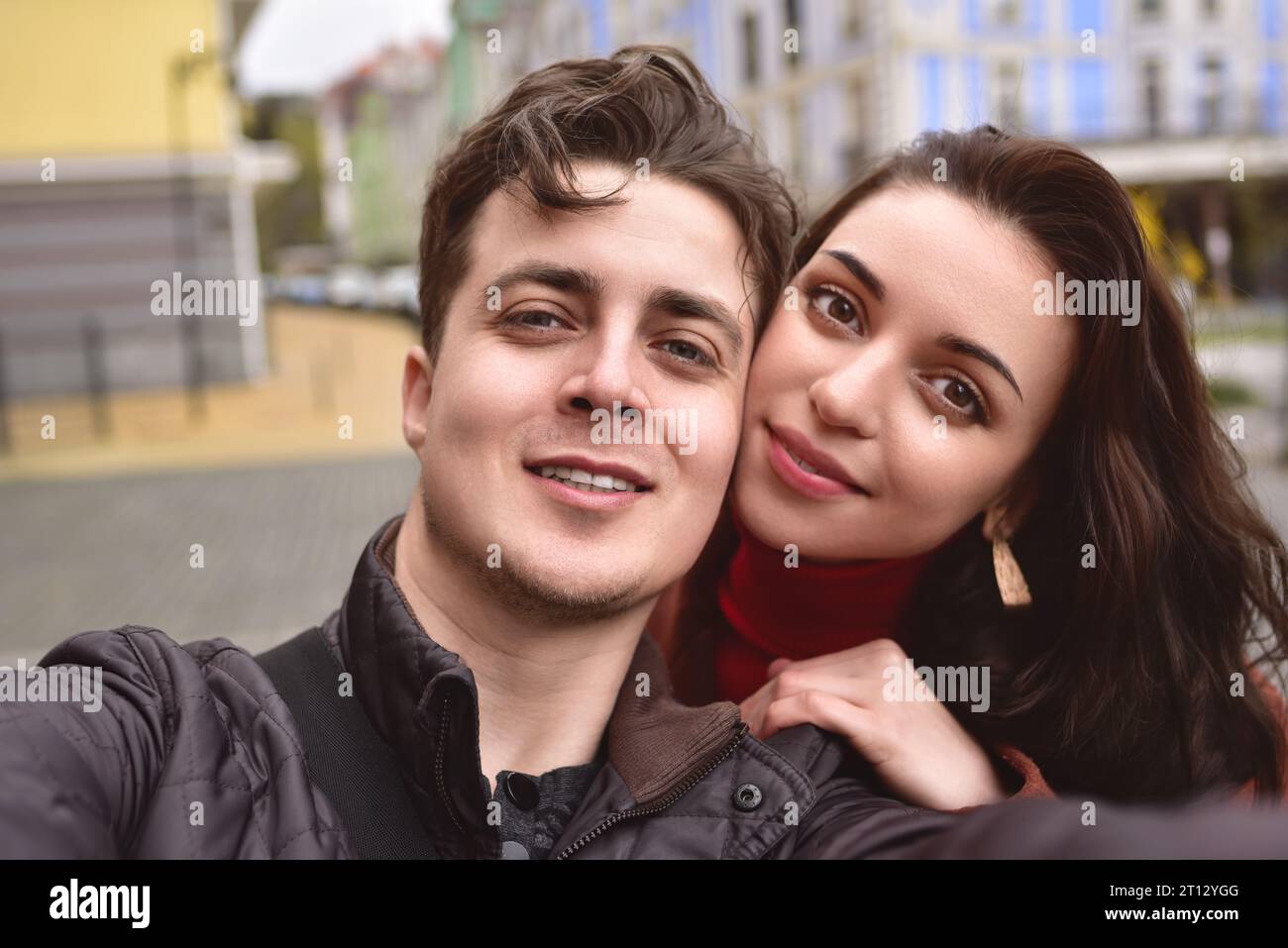 A beautiful young couple takes a selfie on the street. A couple in love take a selfie together. Stock Photo