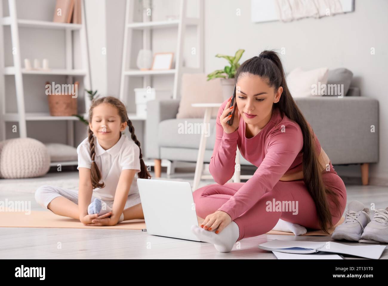 Working mother with her little daughter training at home Stock Photo ...