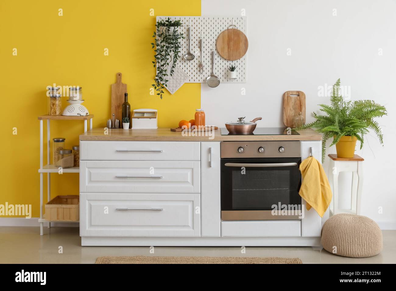 Interior of stylish kitchen with oven, white counters and pegboard ...