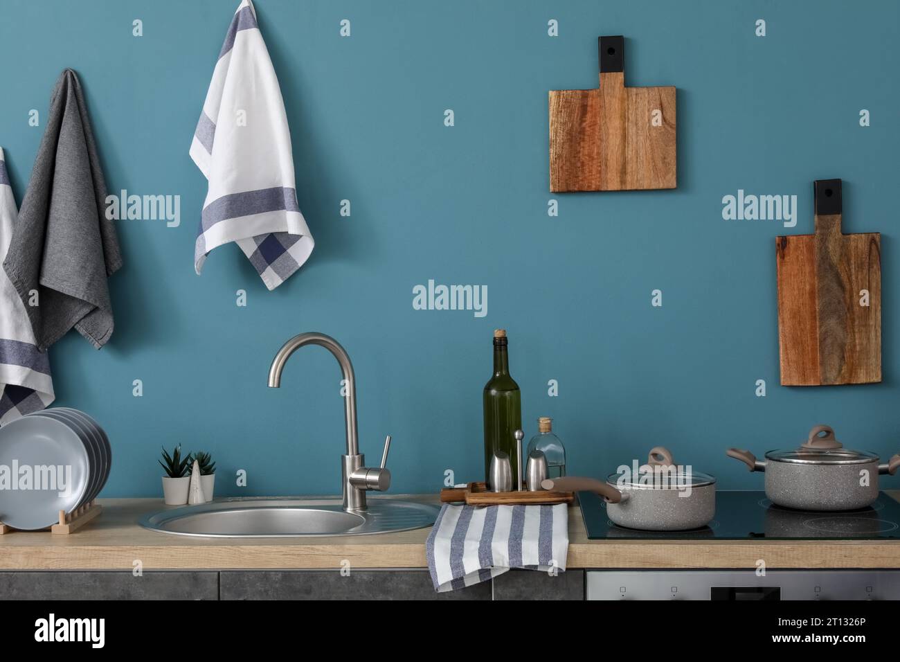 Interior of modern kitchen with grey counters, cutting boards and ...