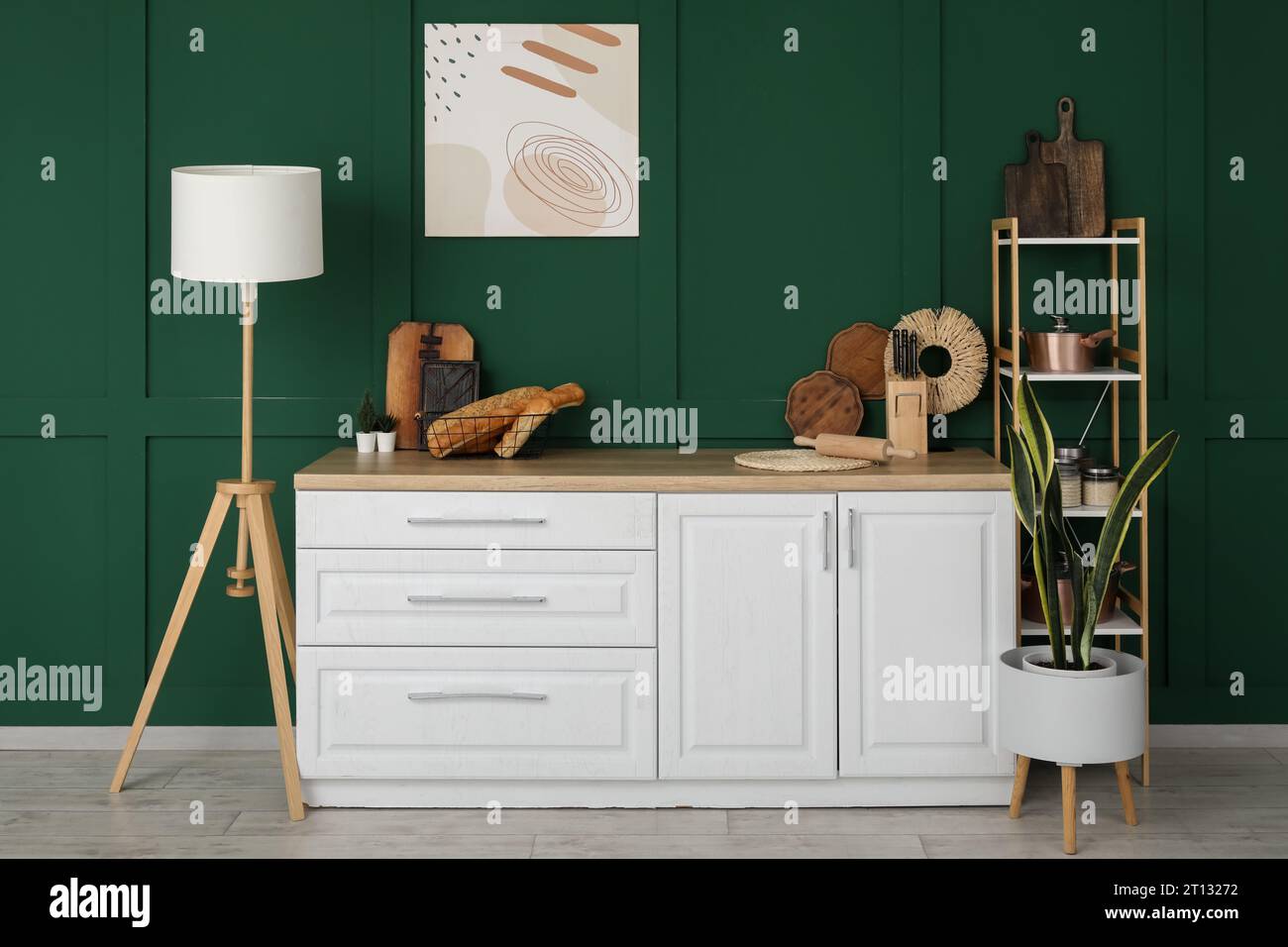 Interior of modern kitchen with white counters, lamp and shelving unit ...