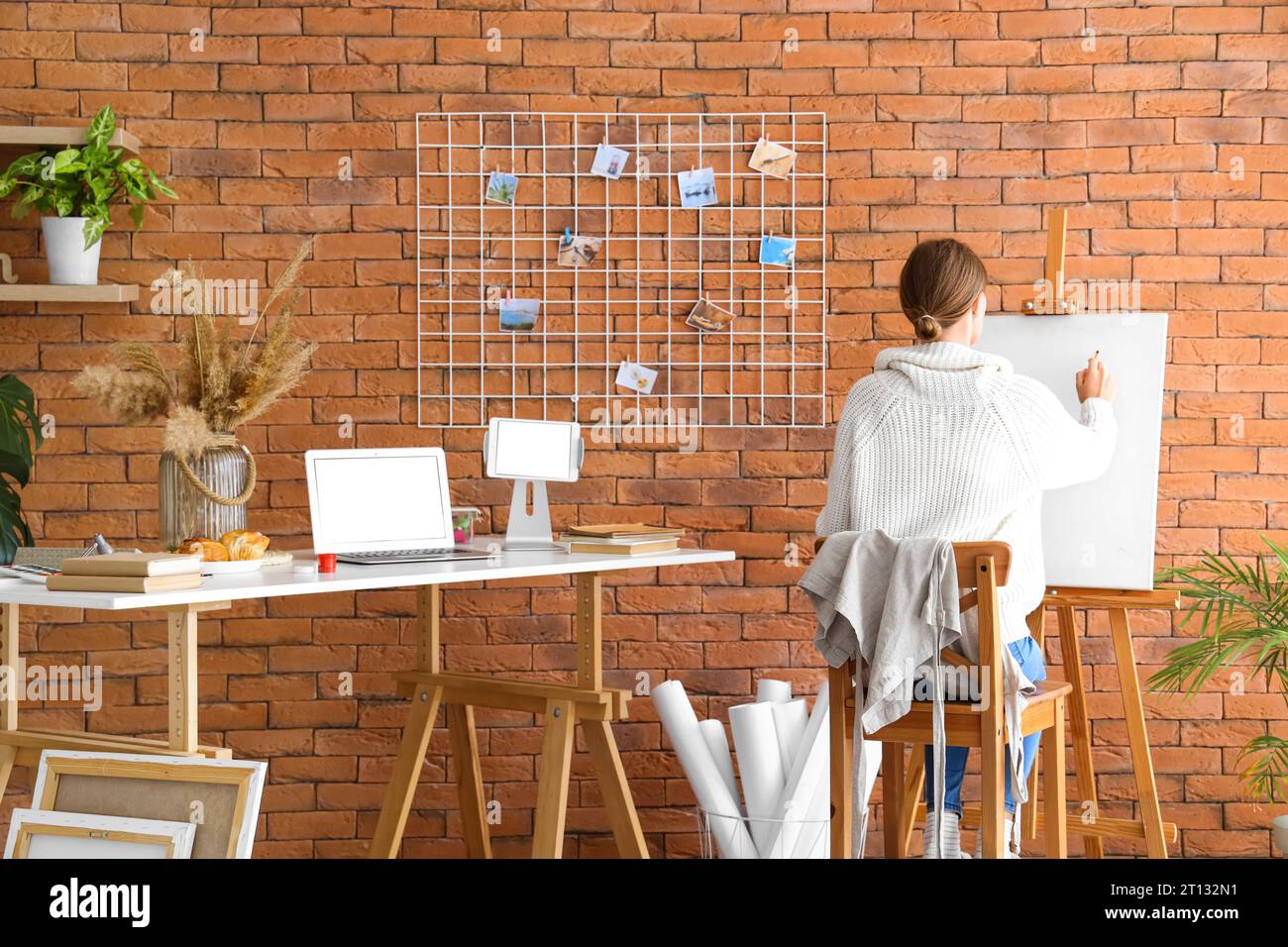 Female artist painting on easel in studio, back view Stock Photo - Alamy