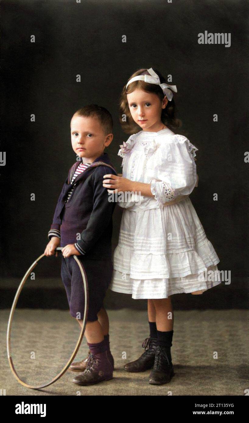 1911 , september , DETMOLD , GERMANY : Two children , brother  and sister . The boy named Wilhelm Heinrich and young girl named Gertrud . Photo by Reckmam , Detmold  . DIGITALLY COLORIZED . - North Rhine-Westphalia - FAMILY - FAMIGLIA - DUE - TWO FRATELLI - FRATELLO - BROTHER - SORELLE - SORELLA - GERMANIA  - FOTO STORICHE - HISTORY PHOTOS - BAMBINO - BAMBINI - BAMBINA - BAMBINE - CHILDREN - CHILD - BABY - CHILDHOOD - INFANZIA - BABY -  ANNI DIECI - '10 - 10's - vestito alla marinara - marinaretto - marina - sailor dress - cerchio - cerchione - TOY - GIOCO - GIOCATTOLO - GIOCO - BIG RIM - FASH Stock Photo