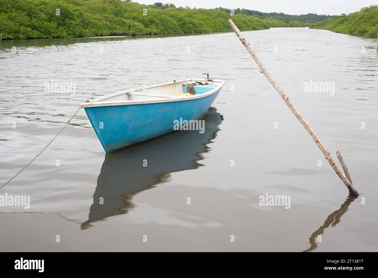 A blue and white boat anchored in a river waiting to depart. Fishing ...