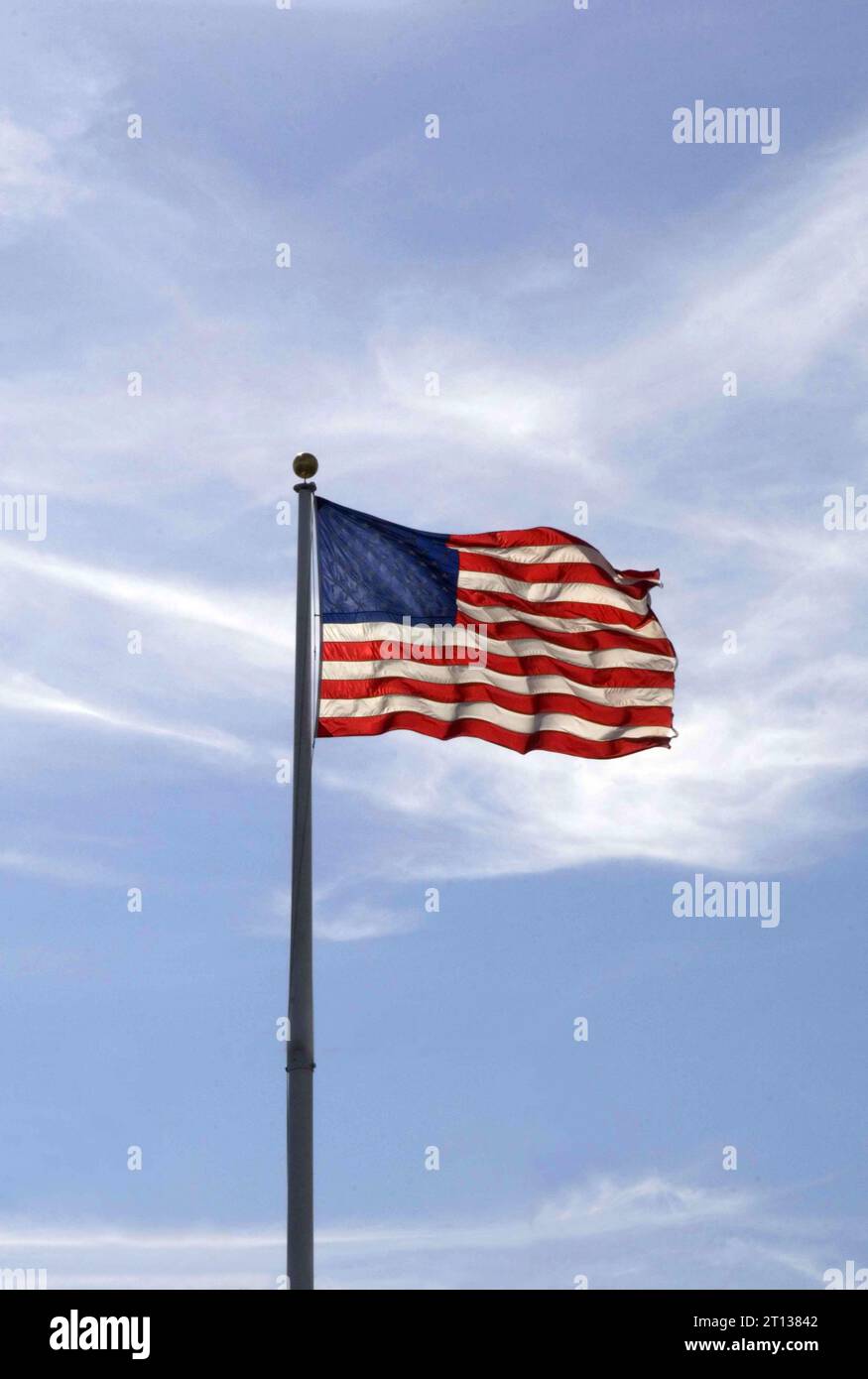 The US flag with stars and stripes blowing in the breeze on a sunny day. Stock Photo