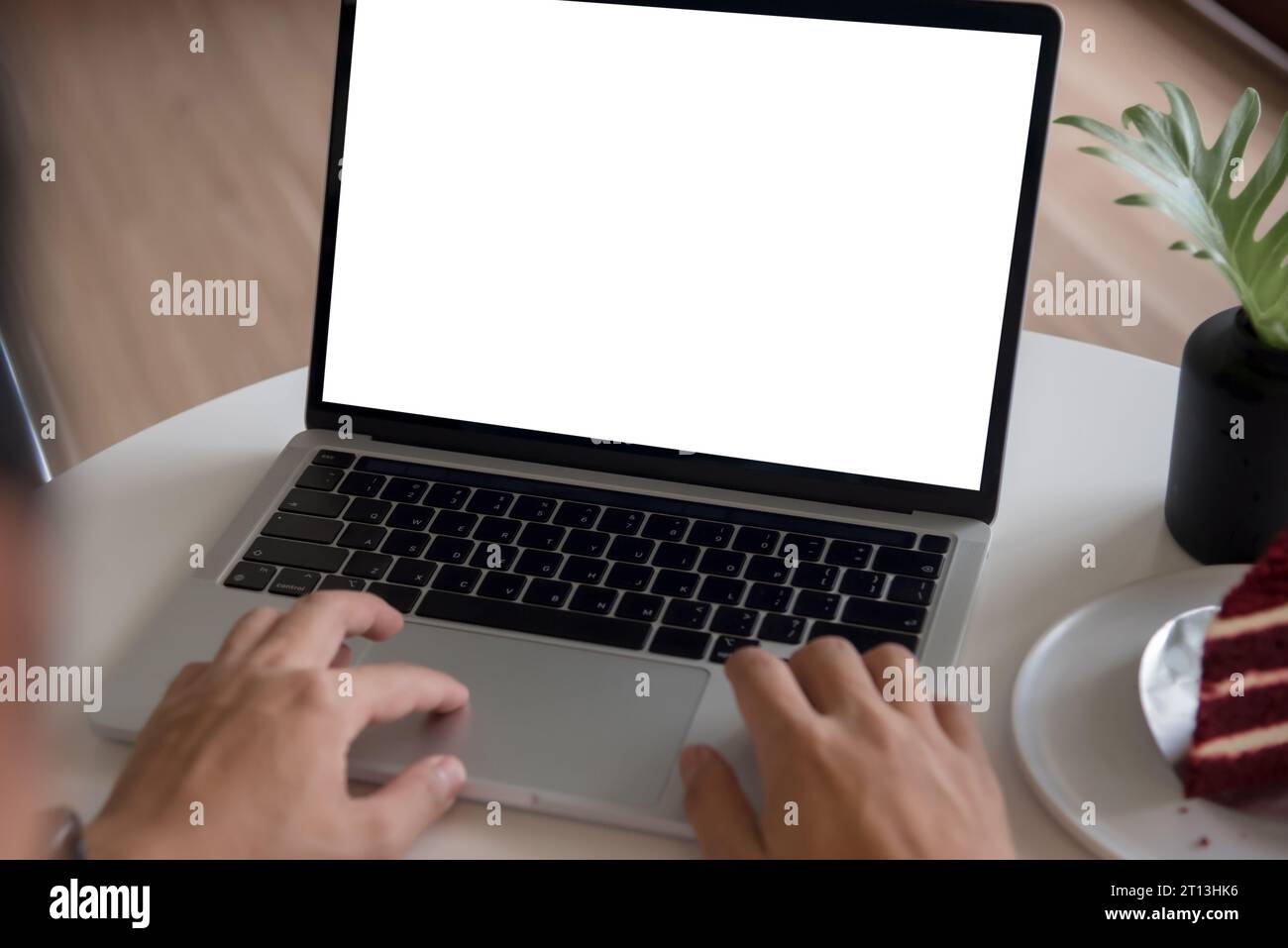 man using and typing on laptop computer mockup with blank screen. Stock Photo
