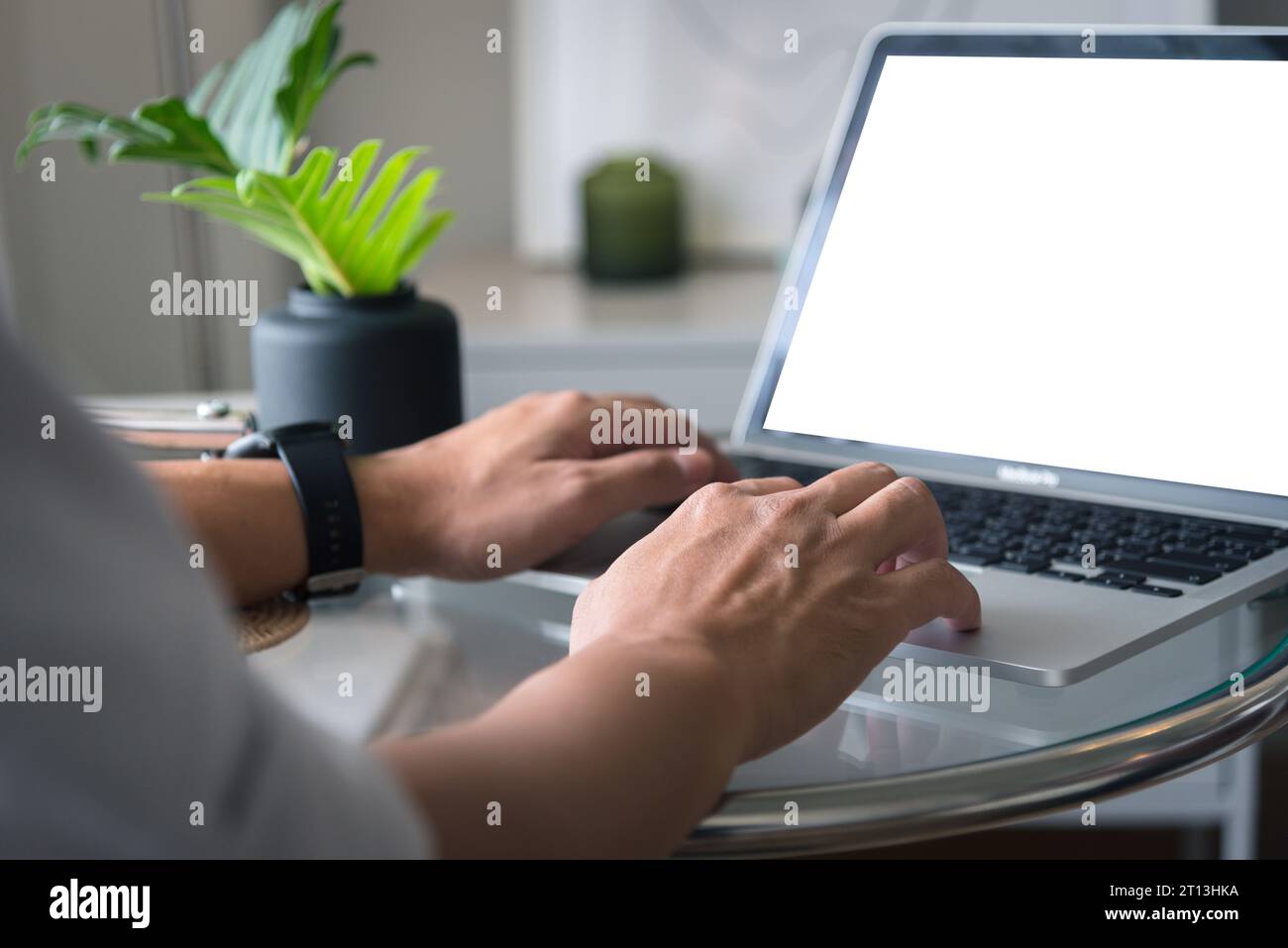 man using and typing on laptop computer mockup with blank screen. Stock Photo