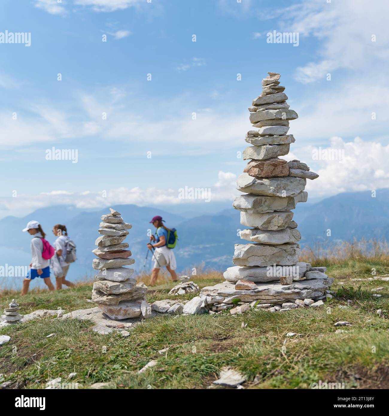stones piled up by tourists and some hikers on the mountain top of Monte Baldo at Lake Garda near Malcesine in Italy Stock Photo