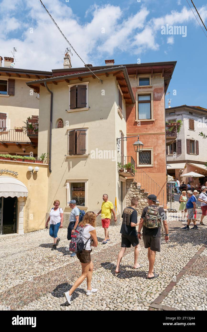 Tourists in an alley in the popular resort of Malcesine on Lake Garda in Italy Stock Photo