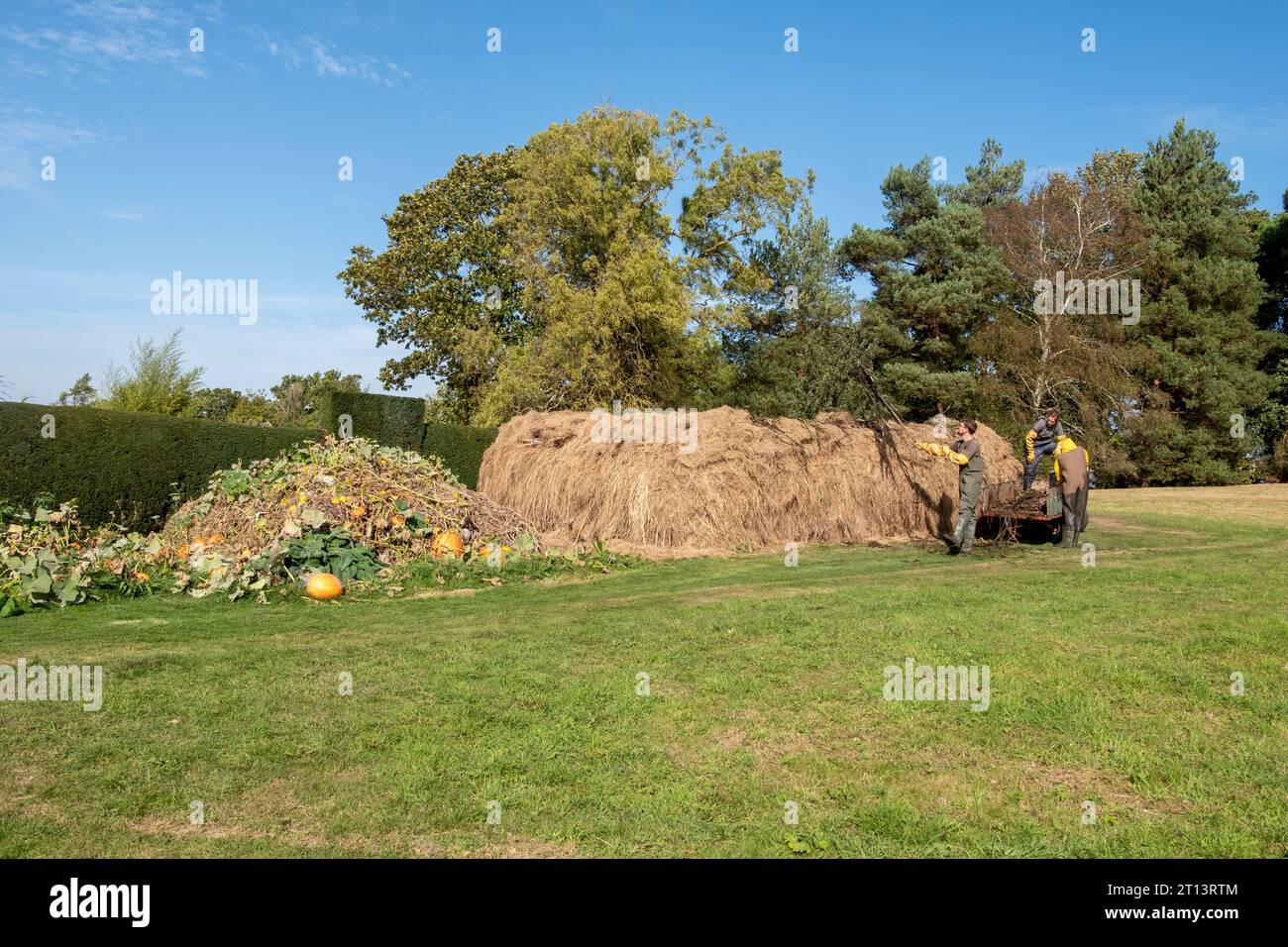 Gardeners working on compost haystack at Great Dixter, East Sussex, UK Stock Photo