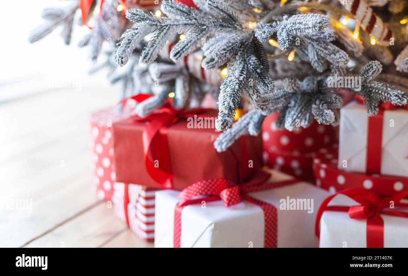 Beautiful Christmas gift boxes on floor near fir tree in room Stock ...