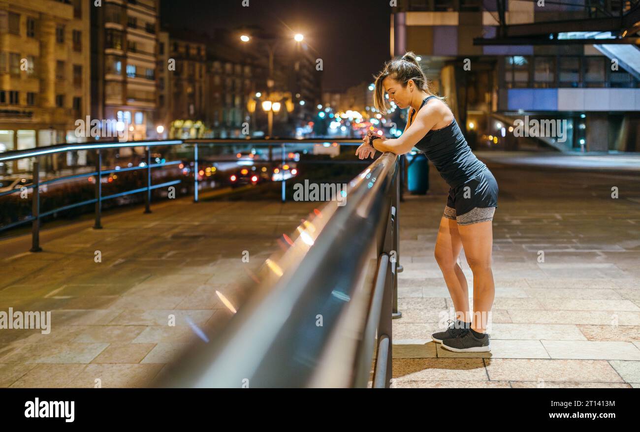 Young blonde runner woman checking exercise progress on smart watch application after training Stock Photo