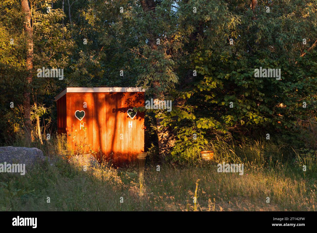 Old times outdoor dry toilet, outhouse, privy in red. Bushy environment Stock Photo - Alamy