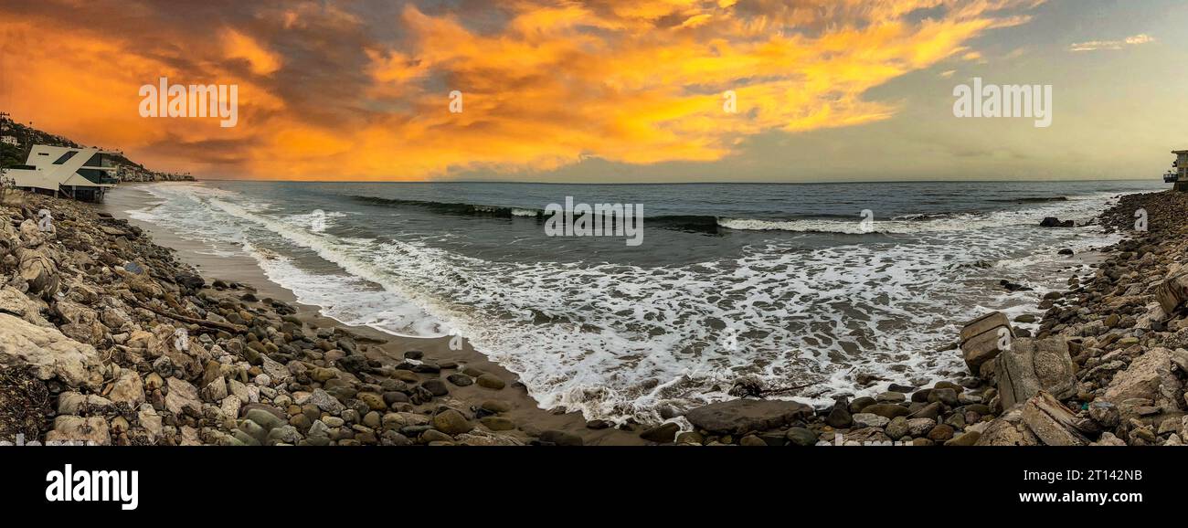 A cliff in the Californian town of Malibu, under a beautiful orange sky, this is a very famous place, frequented by tourists, surfers and movie celebr Stock Photo