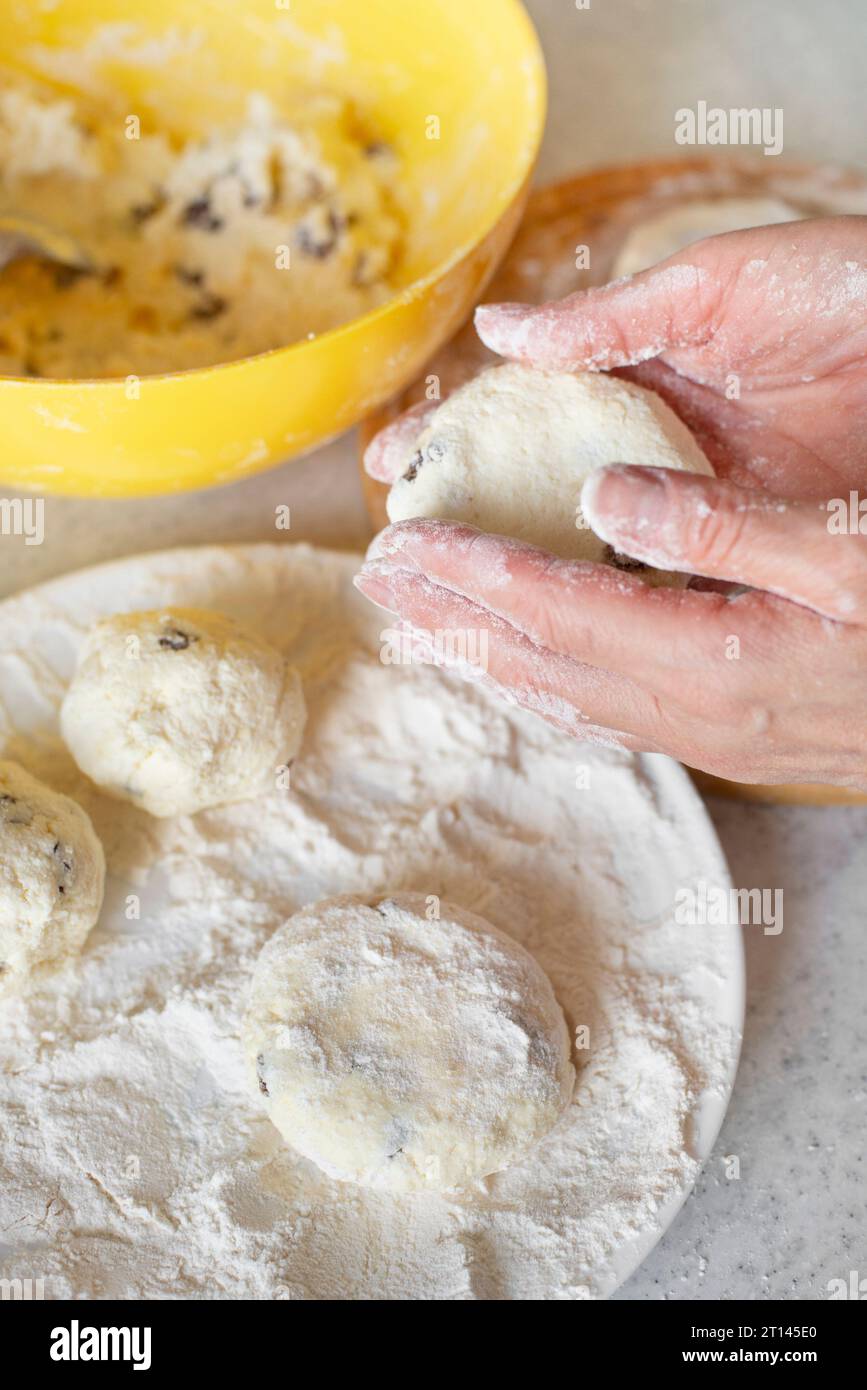 Caucasian female hands making cottage cheese pancakes with raisins cooking background Stock Photo