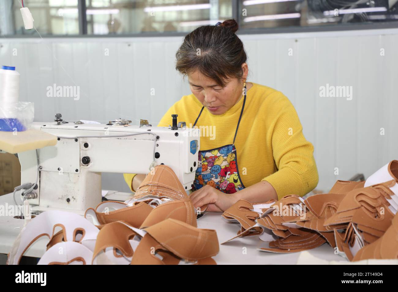 Shoe Processing A worker works on the production line of a shoe processing plant in ...