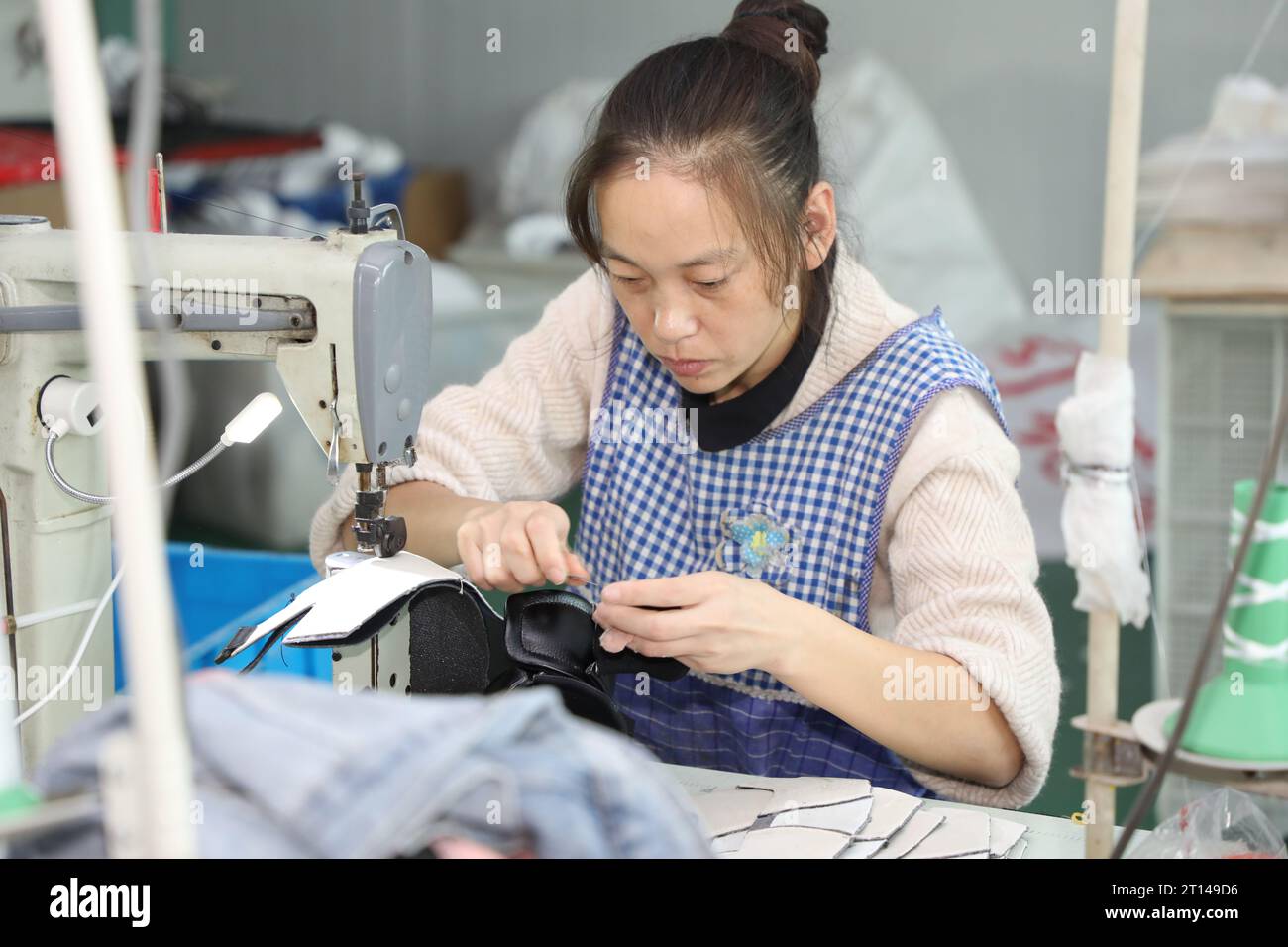 Shoe Processing A worker works on the production line of a shoe processing plant in ...