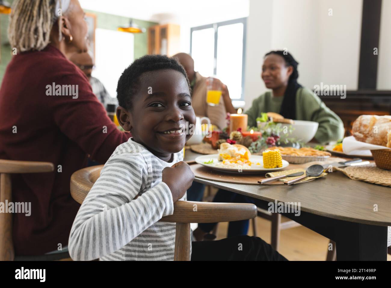 Portrait of african american son with family smiling at thanksgiving dinner table Stock Photo