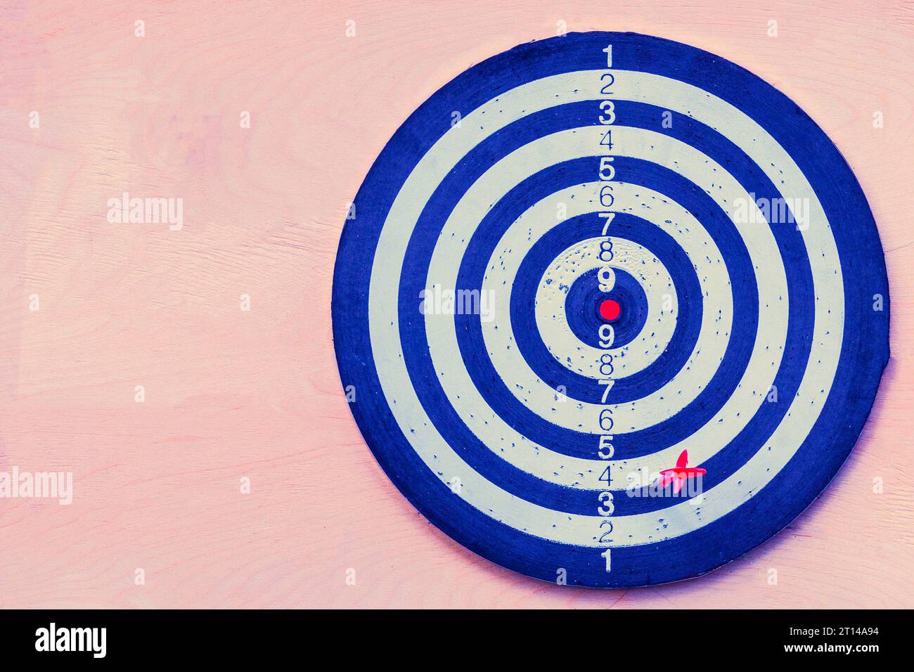 Targets for archery on a green background. Three red darts in the