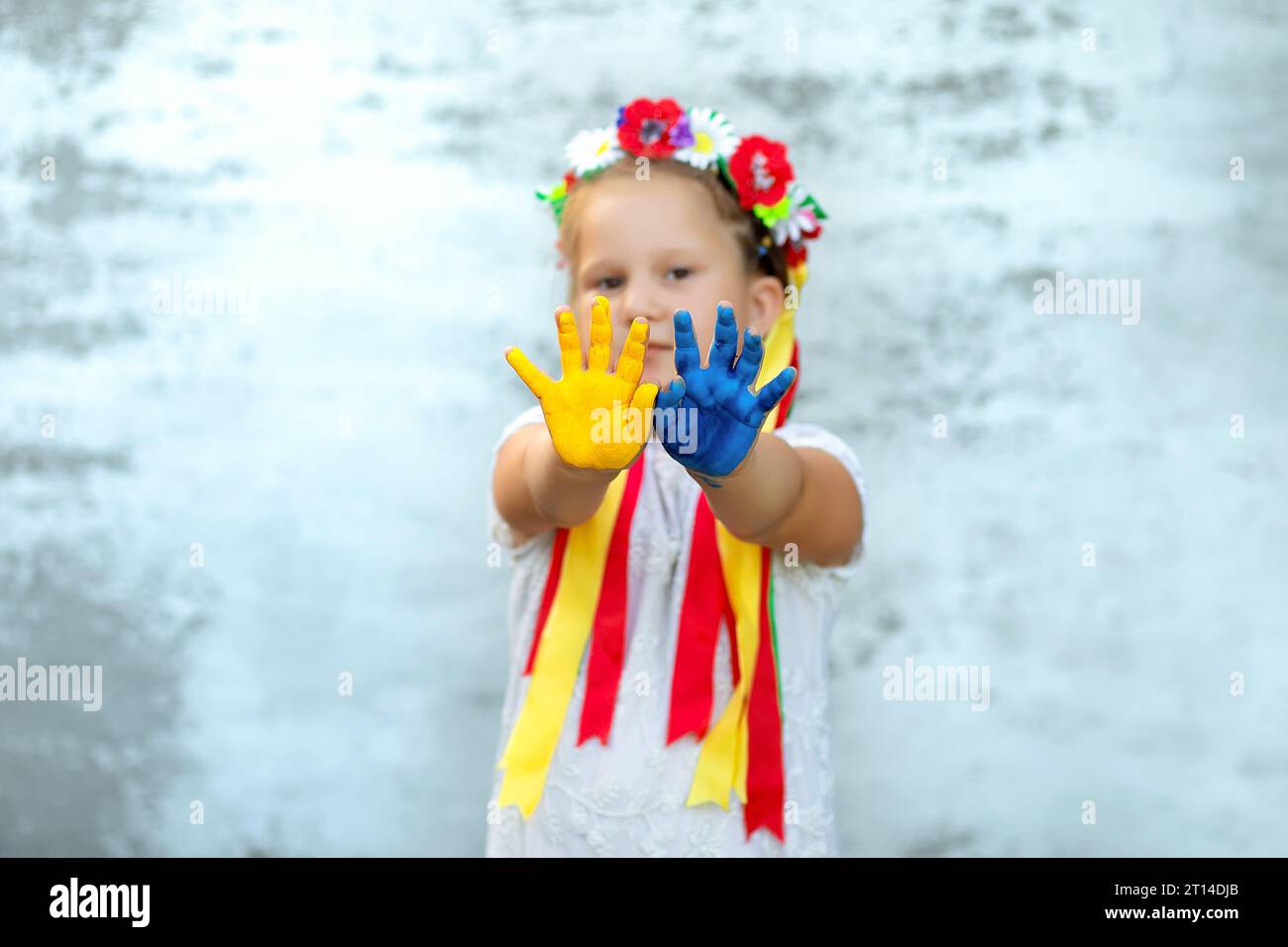 Child girl wearing wheath with ribbons show hands painted in Ukrainian ...