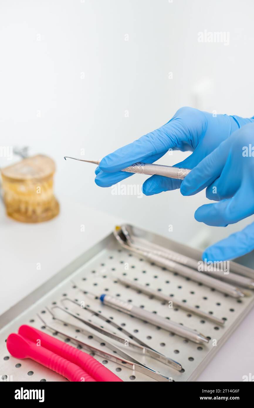 Supporting Tooth Instrument A doctor holding dental instruments for teeth treatment, with jaw model ...