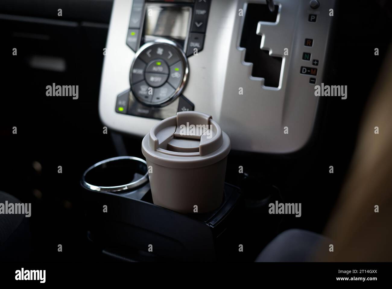 https://c8.alamy.com/comp/2T14GXX/a-travel-coffee-mug-or-tumbler-in-a-car-cup-holder-on-the-drivers-seat-2T14GXX.jpg