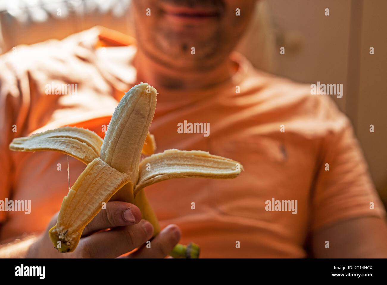 man holding peeled banana before eating Stock Photo