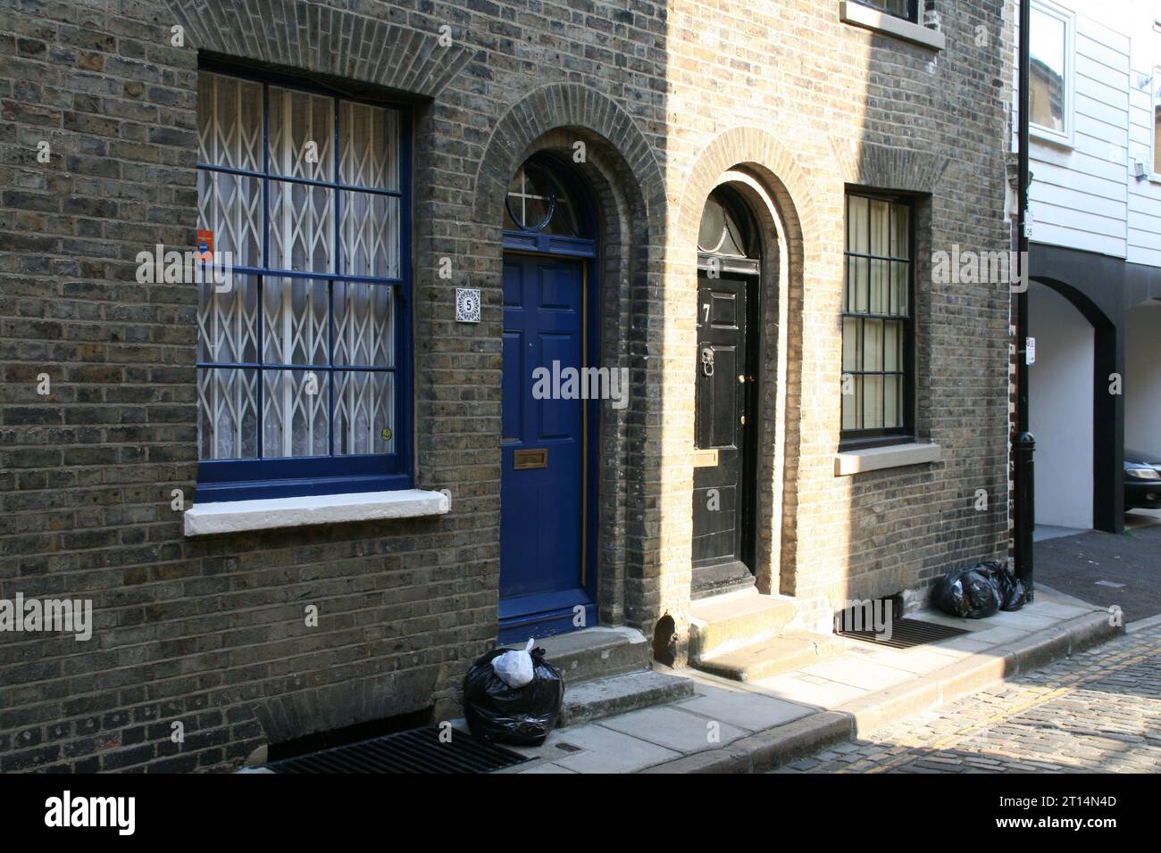 A facade of a modern building with a bright blue door and large windows in London, UK. Stock Photo