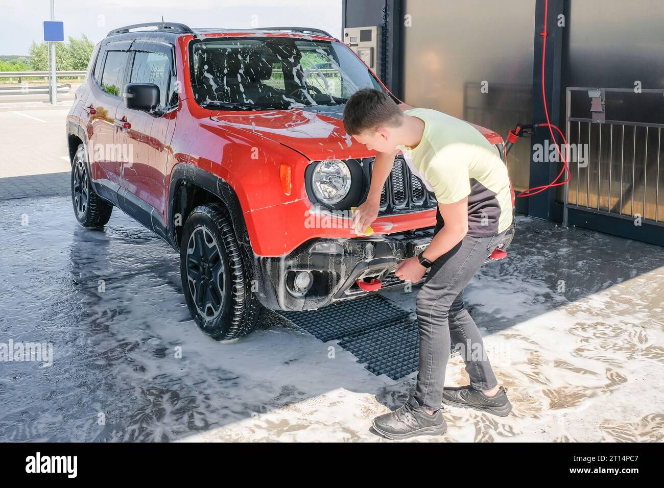 A teenager washes a car with soap at a car wash. Manual car wash Stock Photo Alamy