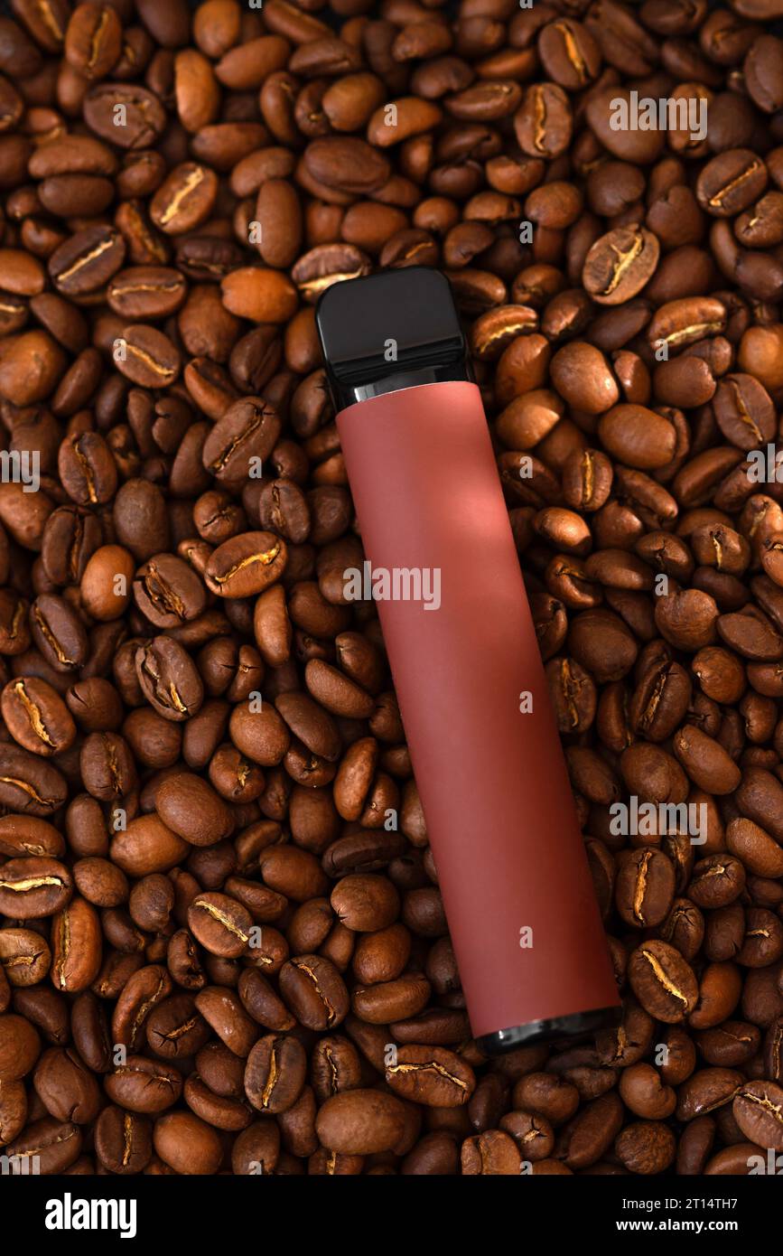 Coffee beans background and E-cigarette. Coffee flavored vape juice concept Stock Photo
