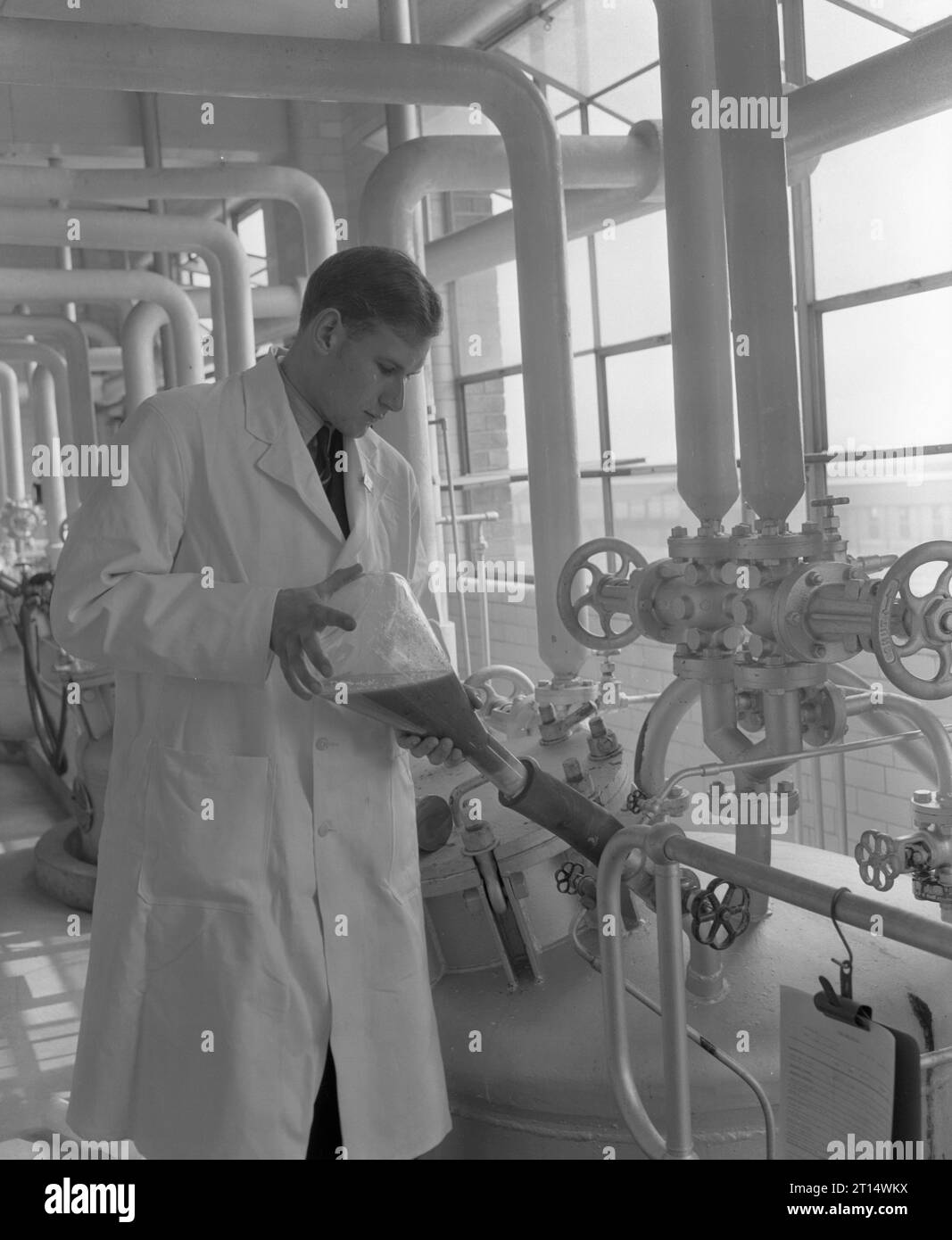 A laboratory assistant is seen injecting mold by flask into a seed tank