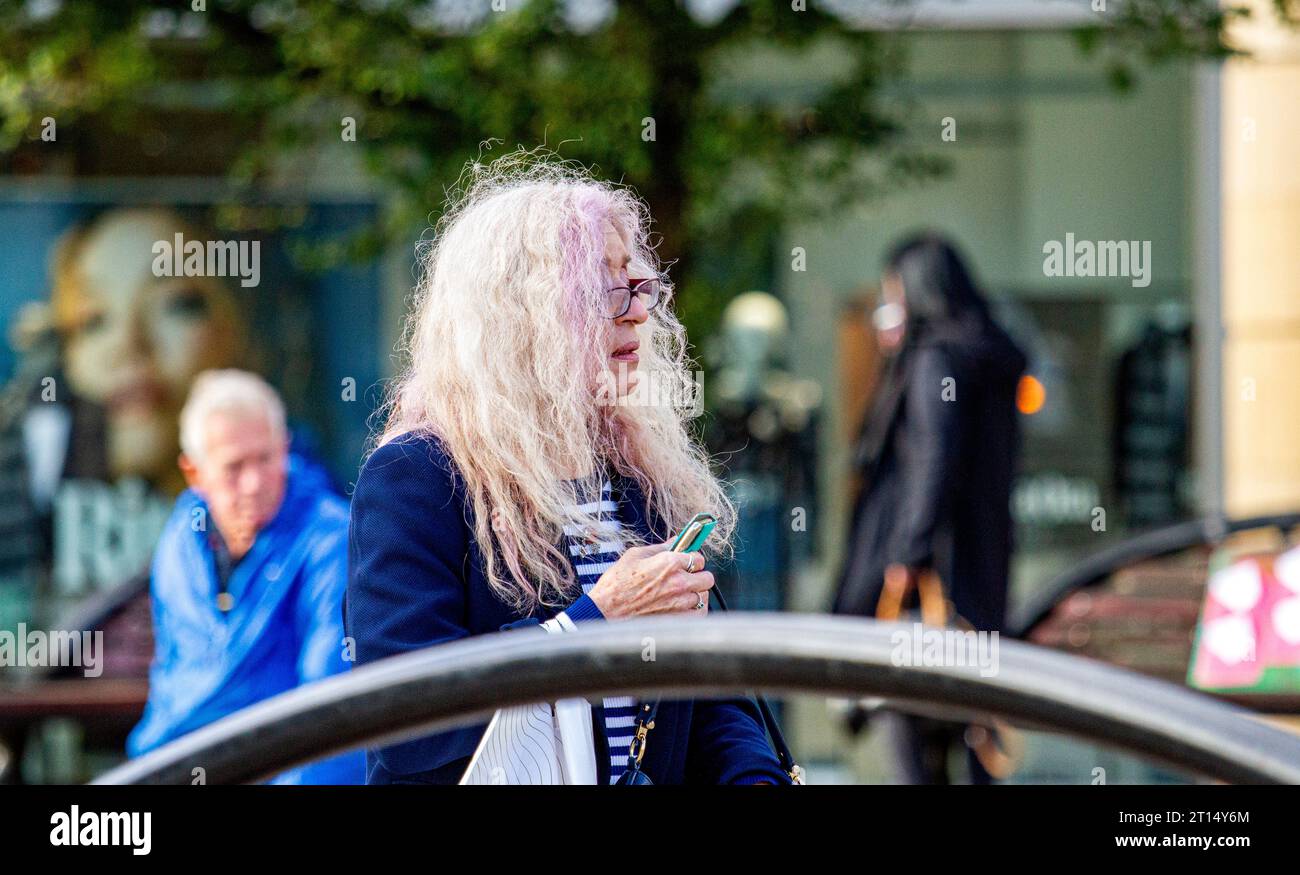 Dundee, Tayside, Scotland, UK. 11th Oct, 2023. UK Weather: Cool wind with brilliant autumn sunshine in Dundee, where temperatures reached 14°C. Local women spend the day having fun in Dundee's city centre, going about their daily lives in the midst of strong winds resulting in a poor hair day. Credit: Dundee Photographics/Alamy Live News Stock Photo