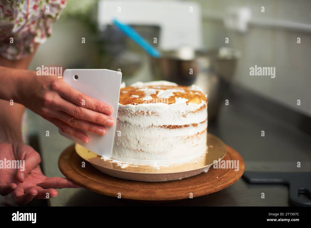 spreading cream cake. kitchen and tools in the background Stock Photo