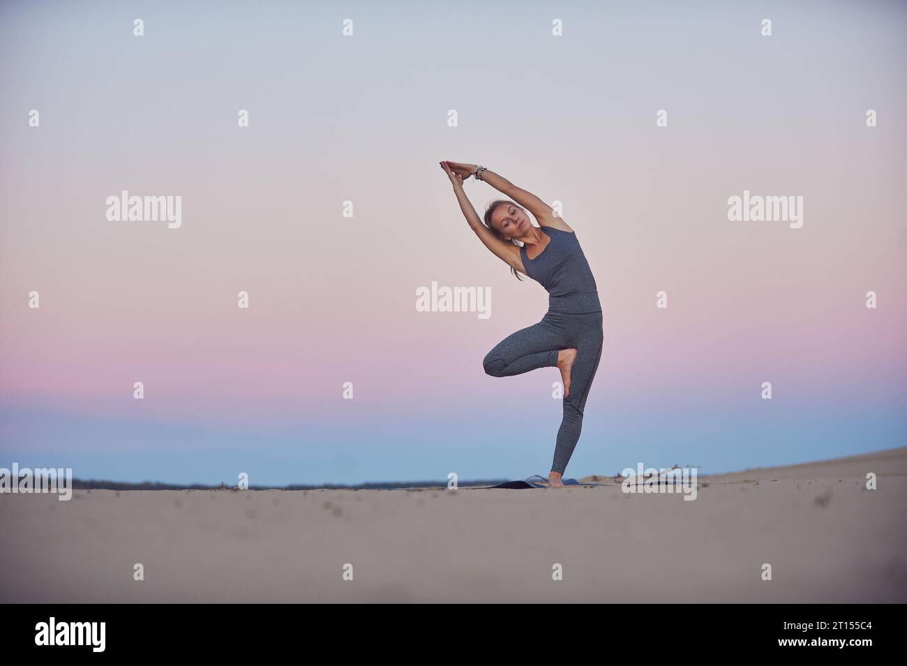 Beautiful young woman practices yoga asana Parshva Vrikshasana - Tree ...