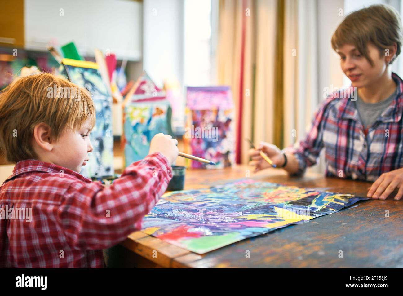 Cute happy little boy and teacher drawing in artist class. Education ...