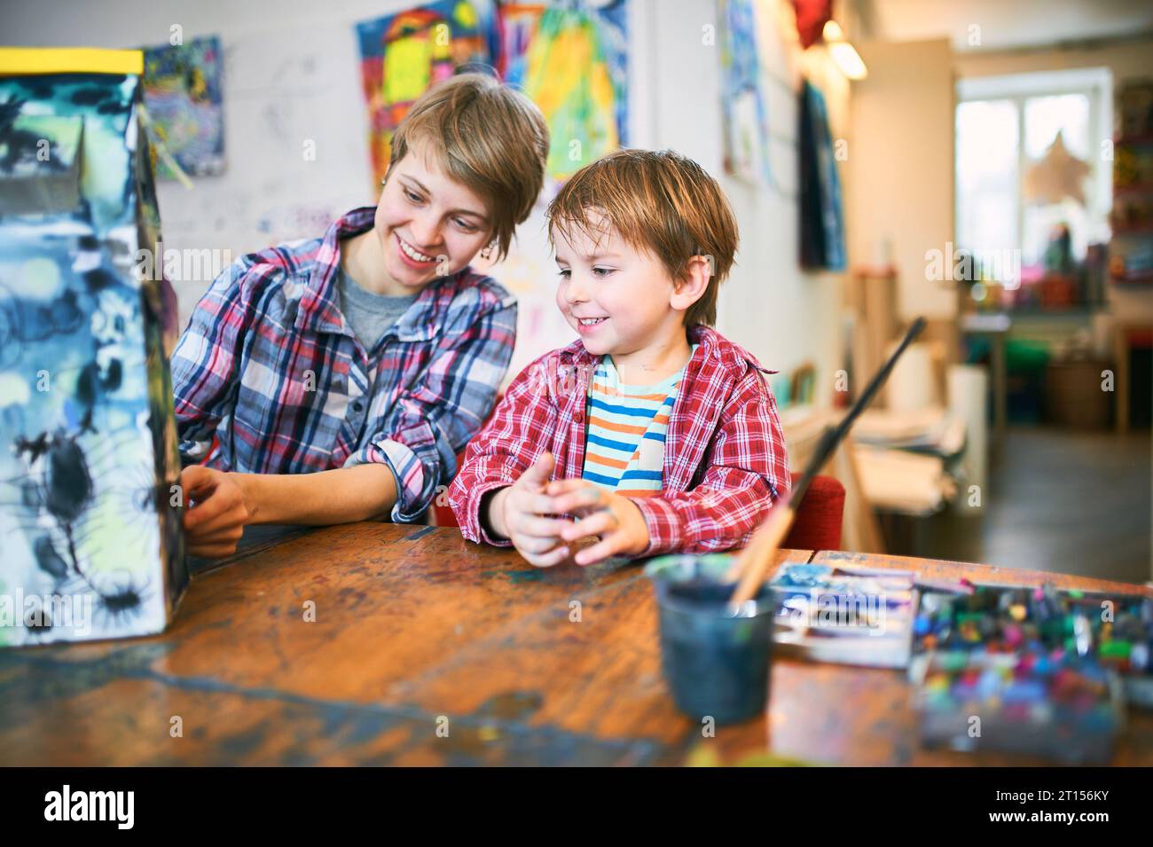 Cute happy little boy and teacher drawing in artist class. Education ...