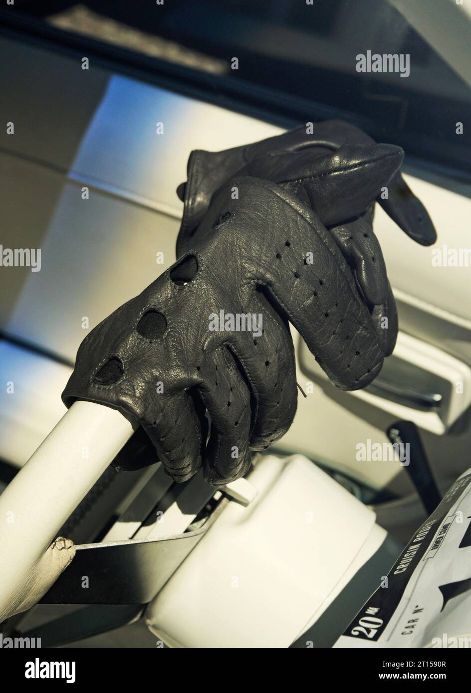 driving leather gloves on the steering wheel of a classic car Stock