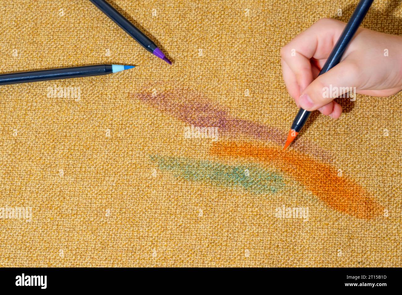 Child's creativity unleashed on yellow upholstery with felttip pen