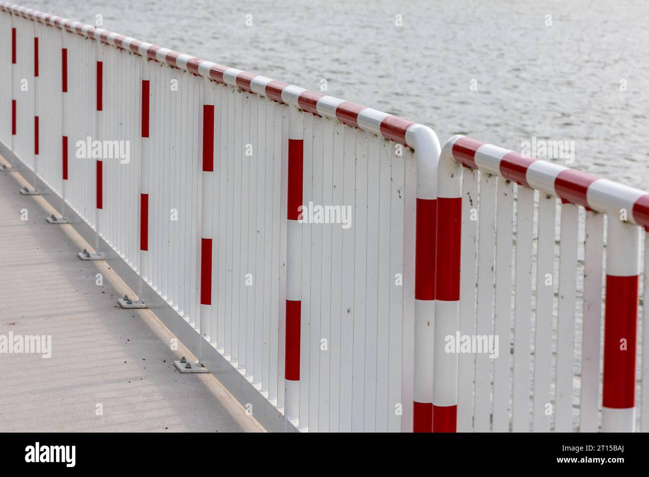 Steel red and white railing on the concrete quay. Safety of the people ...
