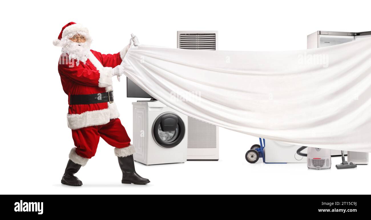 Santa Claus pulling a white piece of cloth in front of home appliances isolated on white background Stock Photo
