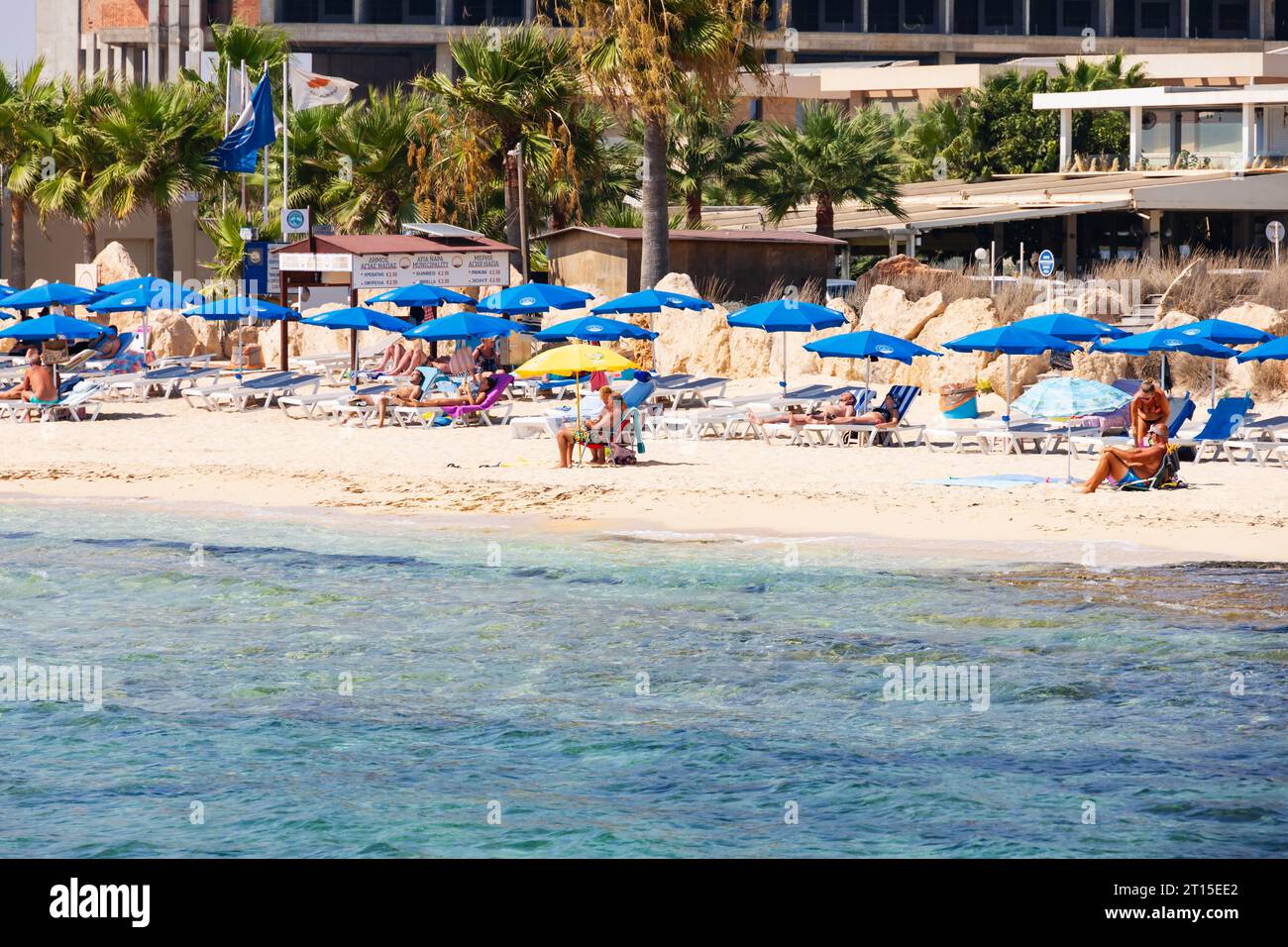 Tourists sunbathe on Ayia Thekla beach, Ayia Napa, Cyprus Stock Photo