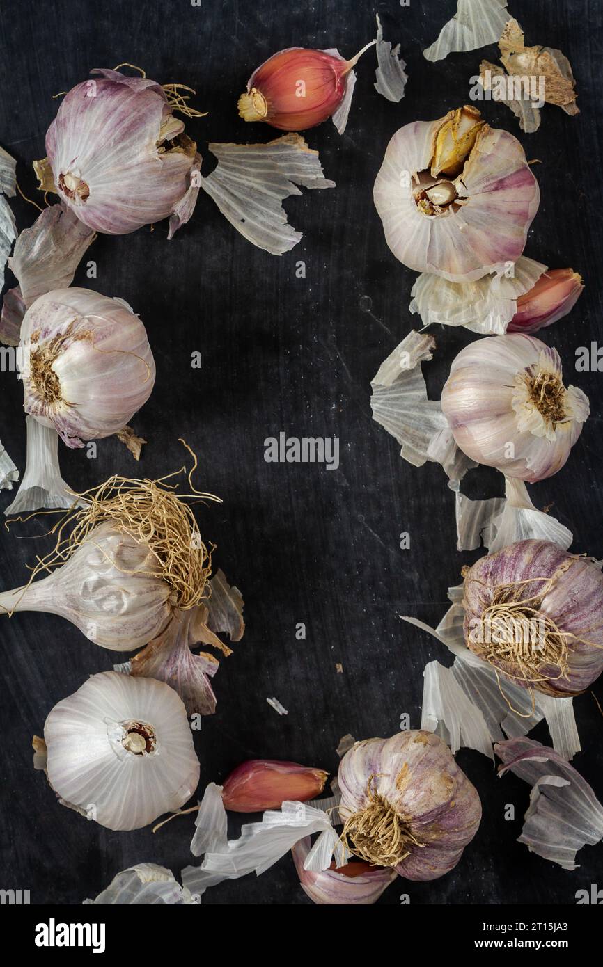 Fresh garlic bulbs and cloves grouped on black background. Flat lay ...