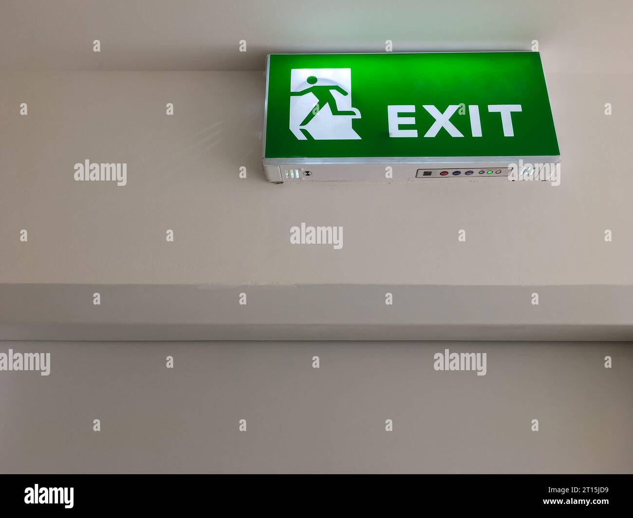 The green fire exit symbol on the ceiling shows escape routes outside the building when the fire, front view with the copy space. Stock Photo